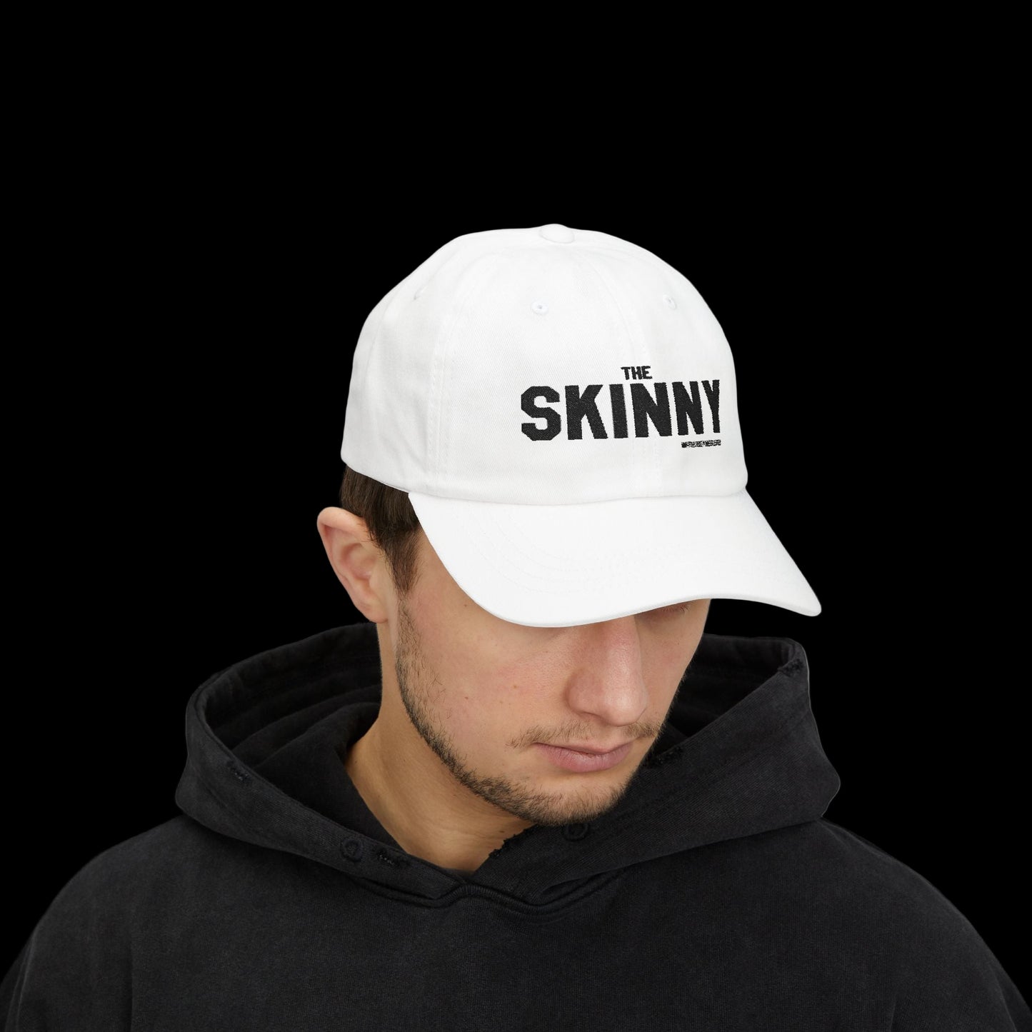 Person wearing a white cap with 'The Skinny' logo on a white background