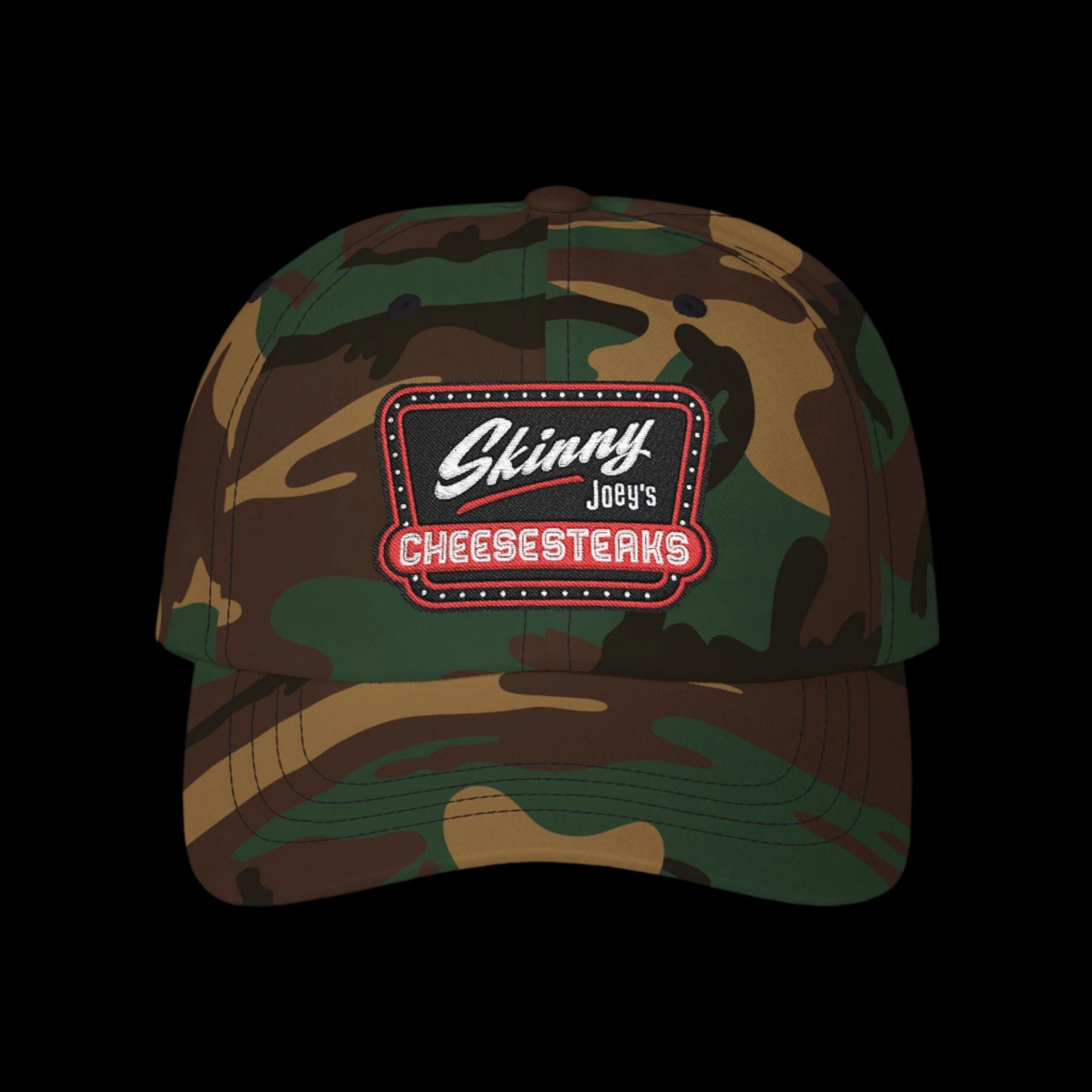 Camouflage cap with a 'Skinny Joey's Cheesesteaks' patch on a black background.Skinny Joey Merlino hat, Skinny Joey merch, Joey Merlino hat, Philly cheesesteak hat, Skinny Joey’s Cheesesteaks streetwear, Joey Merlino apparel, The Skinny Podcast hat, mob-inspired fashion, South Philly cap, Skinny Joey red logo hat.