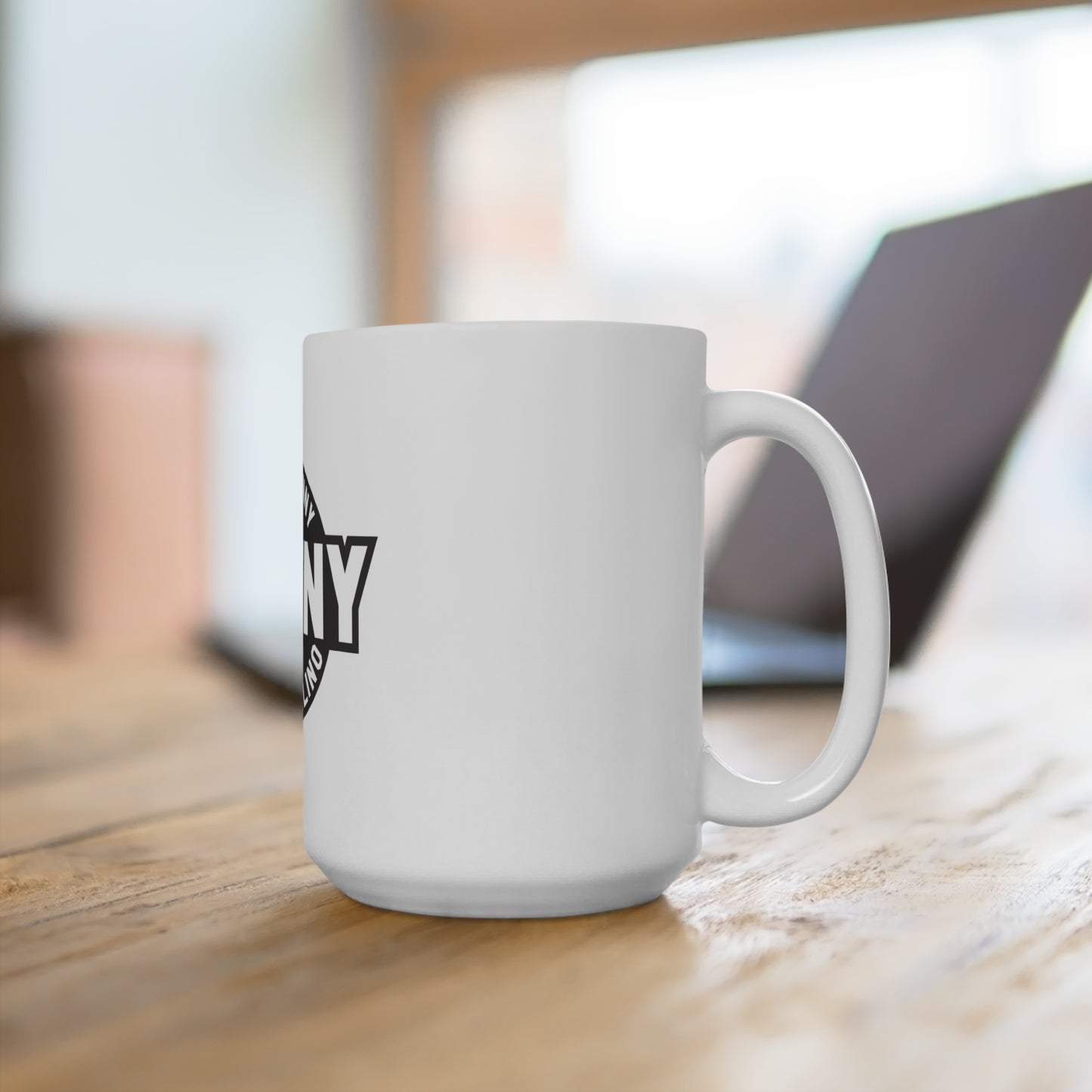 White mug with a black logo on a wooden surface