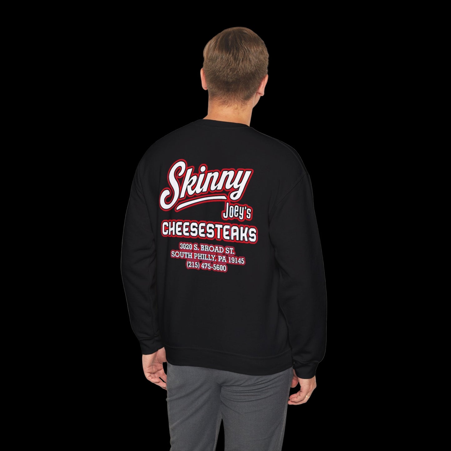 Black sweatshirt with 'Skinny Joey's Cheesesteaks' text on the back, worn by a person.