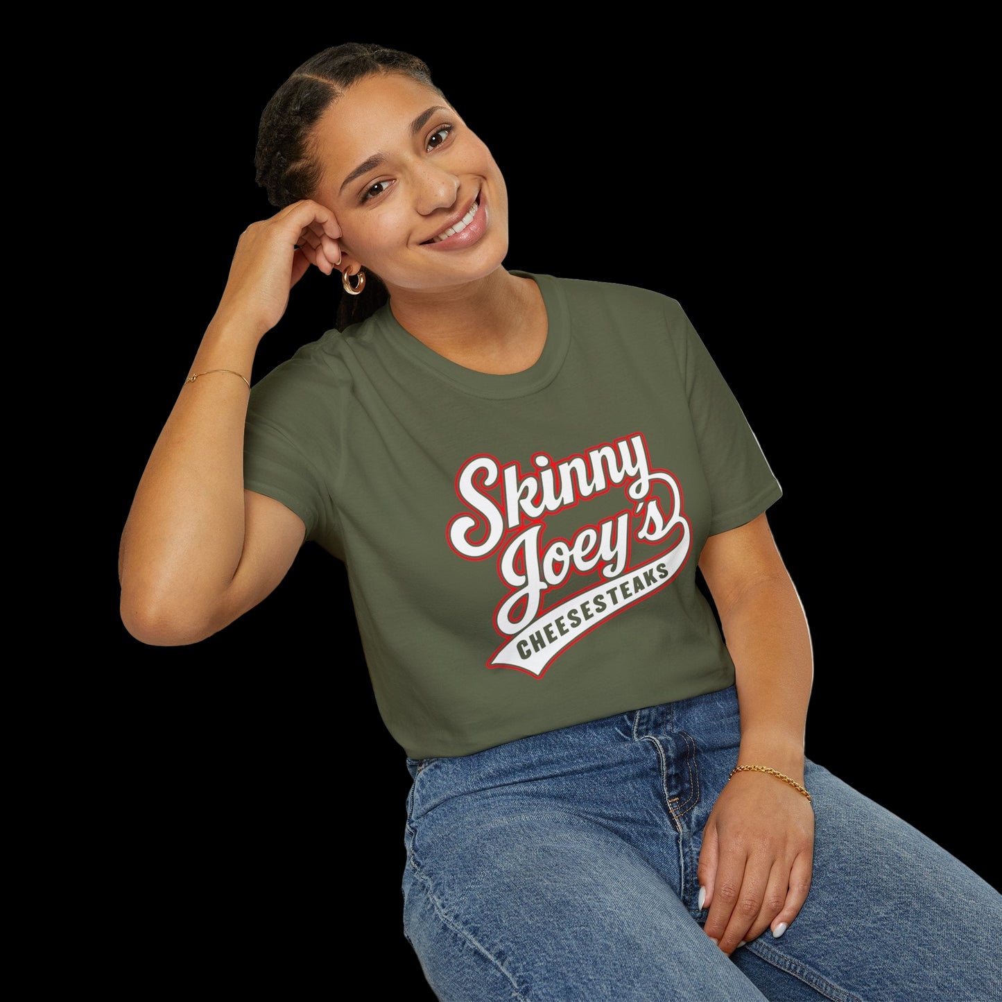 Woman wearing a green t-shirt with 'Skinny Joey's Cheesesteaks' text, sitting on a white background