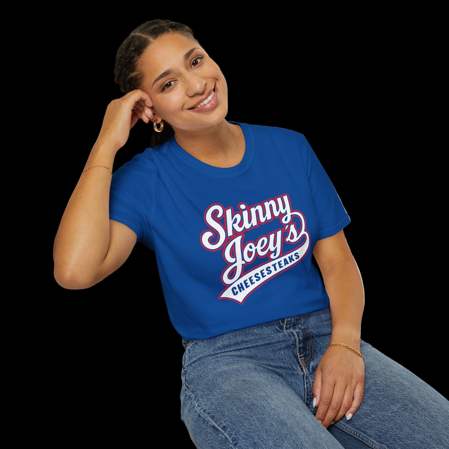 Person wearing a blue t-shirt with 'Skinny Joey's Cheesesteaks' text, sitting on a chair.