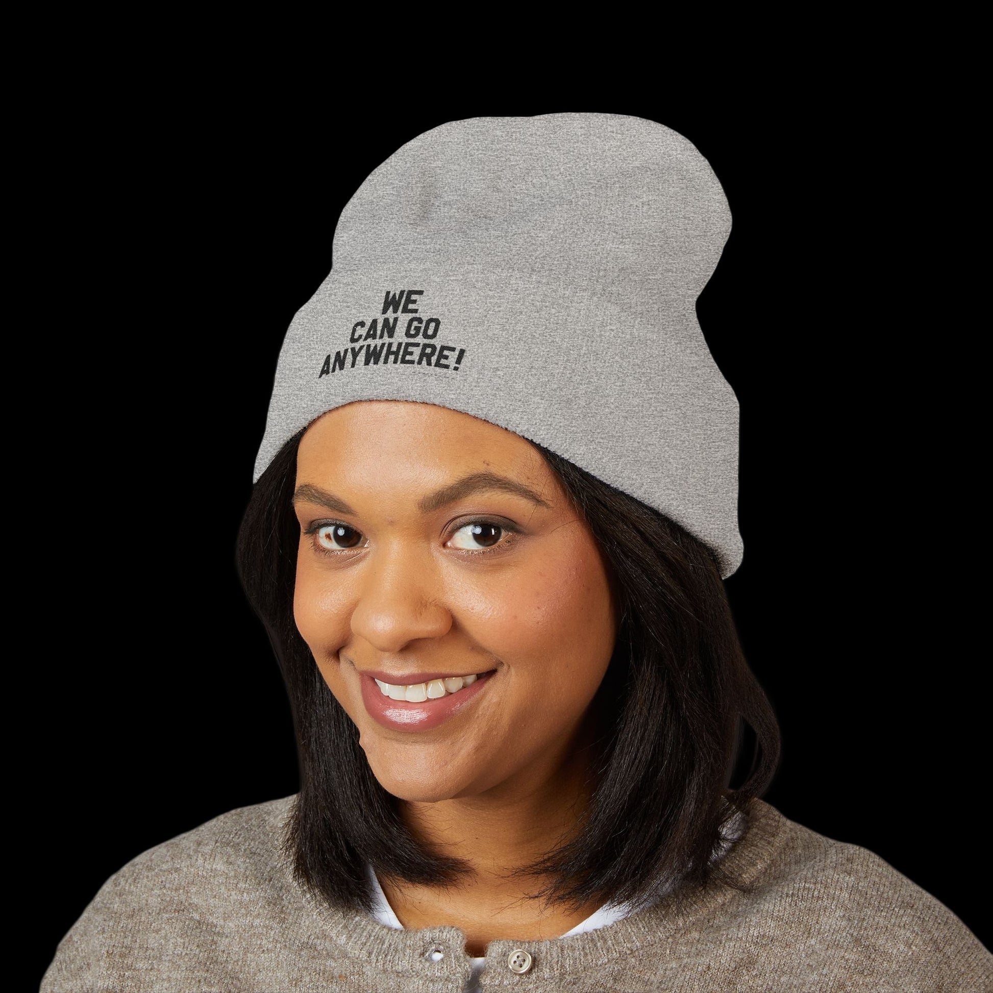 Person wearing a gray beanie with 'WE CAN GO ANYWHERE!' text on a black background
