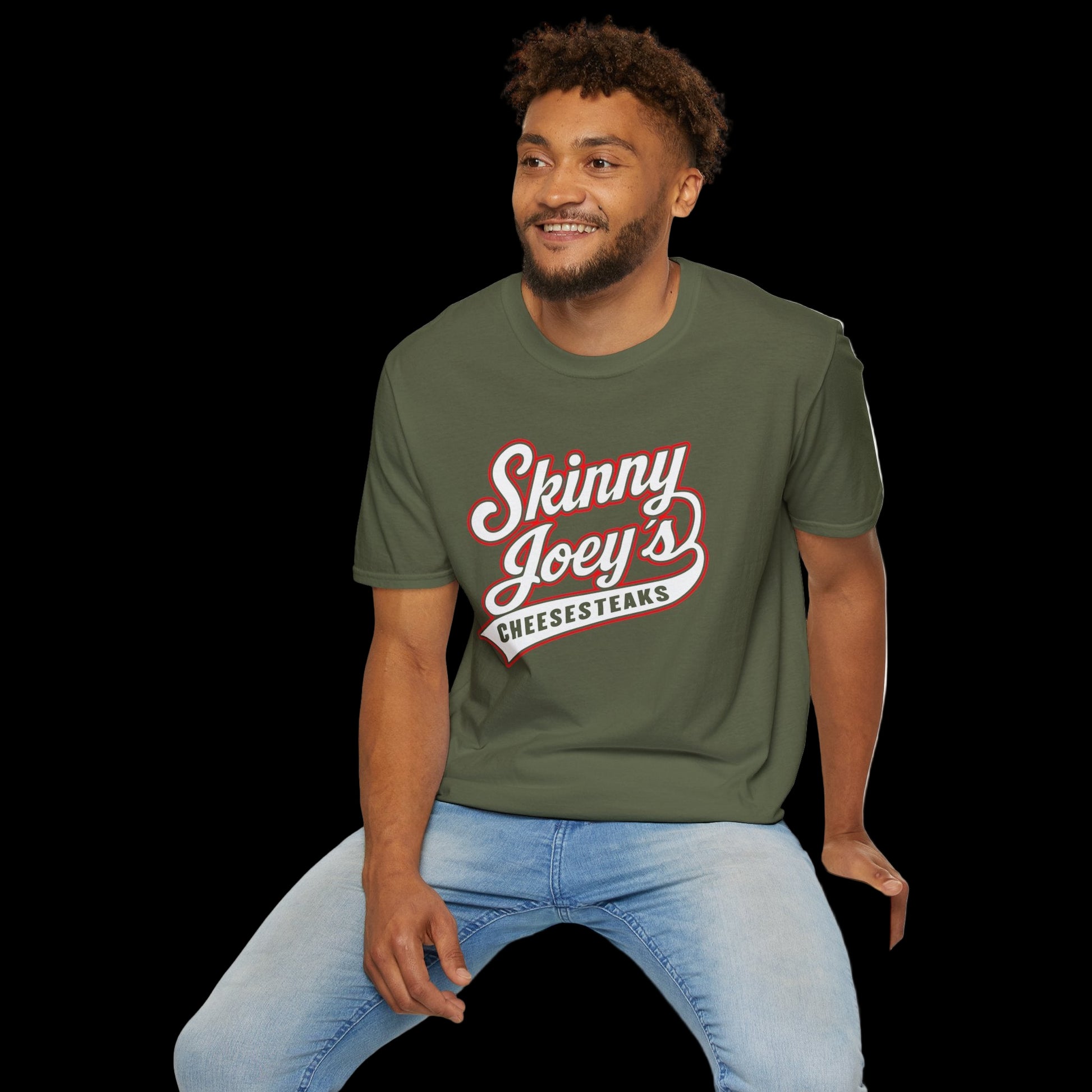 Man wearing a green t-shirt with 'Skinny Joey's Cheesesteaks' text, sitting on a white stool against a white background.