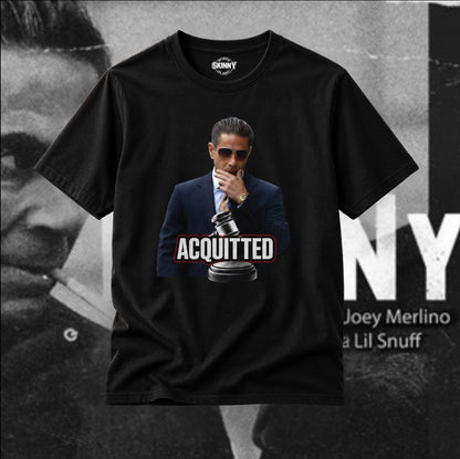 A black short-sleeve graphic t-shirt featuring a printed image of Joey Merlino in a suit and sunglasses with the word 'ACQUITTED' and a gavel. The shirt is displayed against a black-and-white background with text reading 'JOEY MERLINO' and 'Lil Snuff'.
