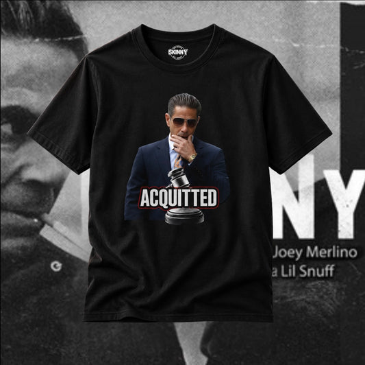 A black short-sleeve graphic t-shirt featuring a printed image of Joey Merlino in a suit and sunglasses with the word 'ACQUITTED' and a gavel. The shirt is displayed against a black-and-white background with text reading 'JOEY MERLINO' and 'Lil Snuff'.