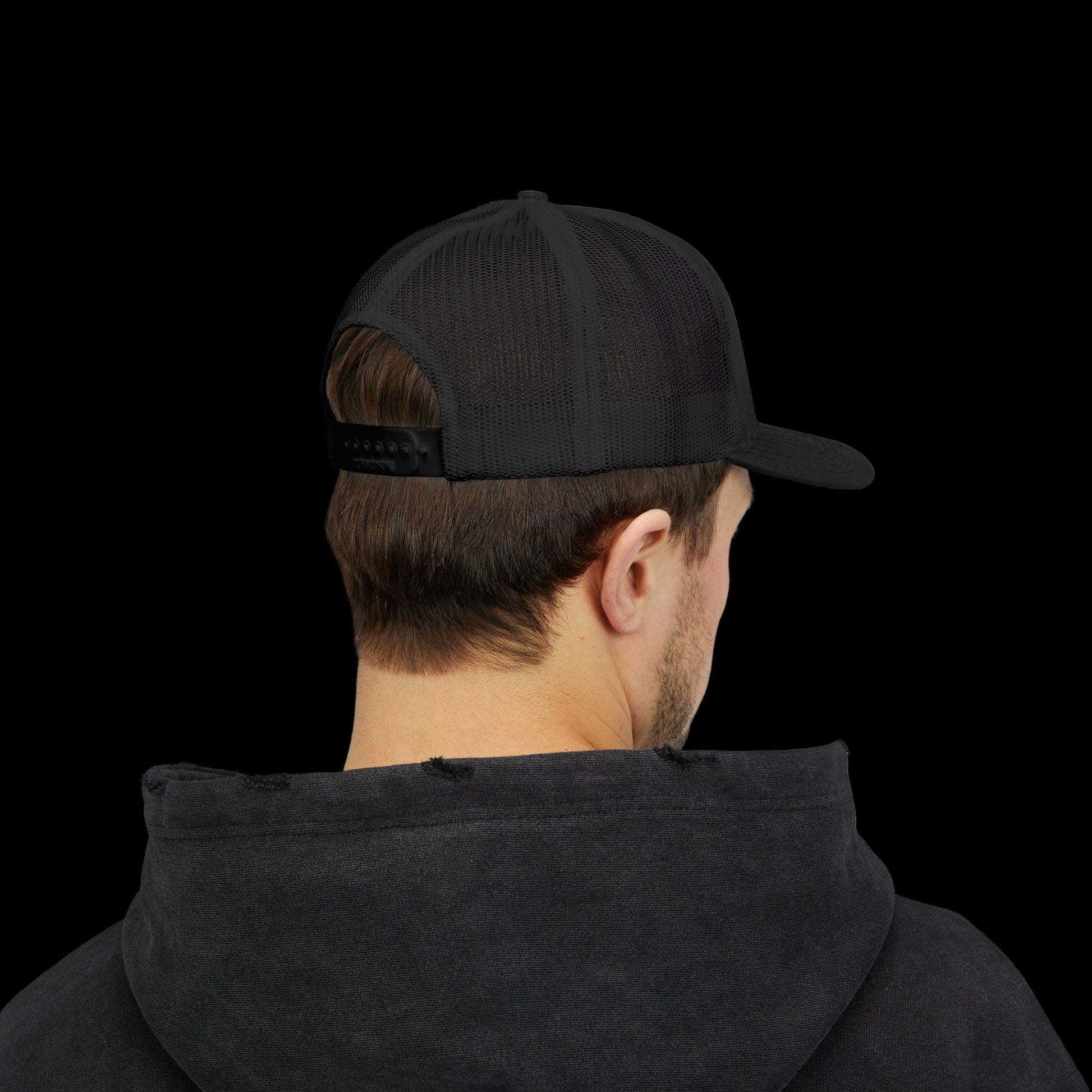 Person wearing a black cap and black hoodie on a white background