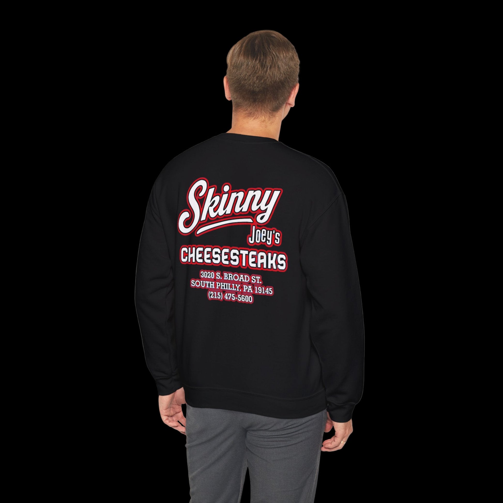 Black sweatshirt with 'Skinny Joey's Cheesesteaks' text on the back, worn by a person.