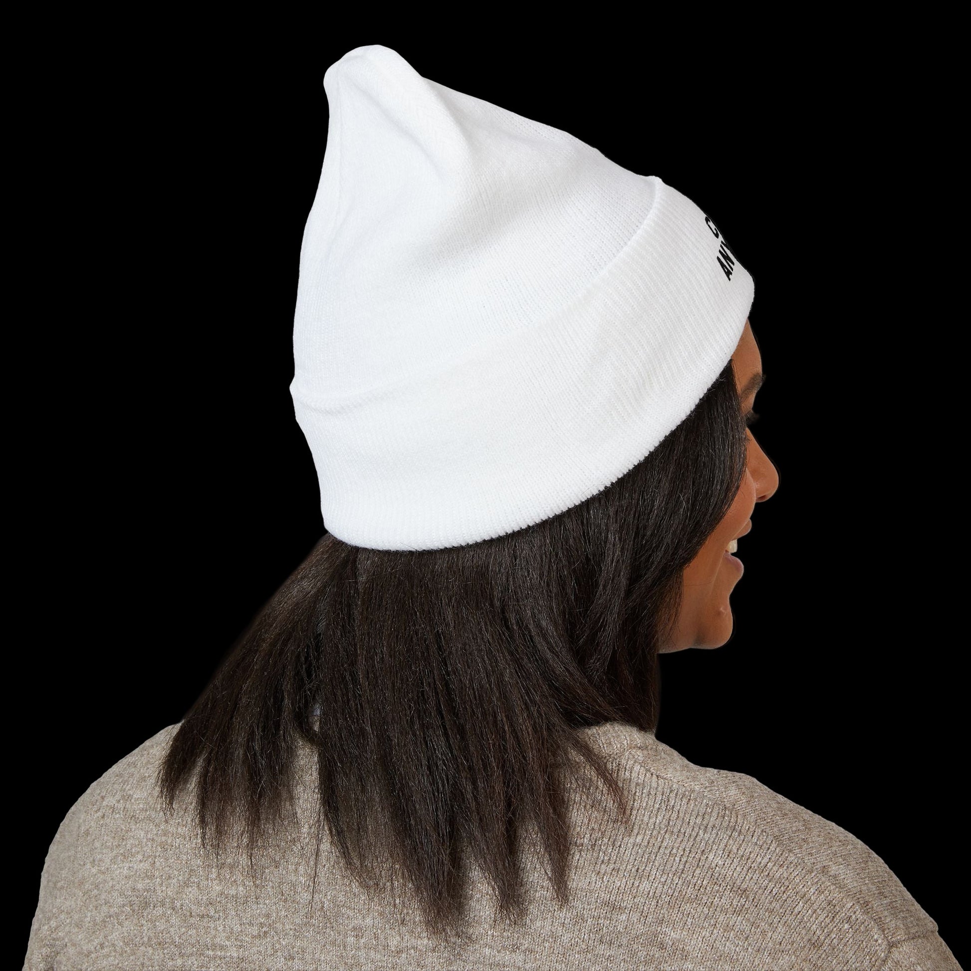Person wearing a white beanie with a brand logo on a black background