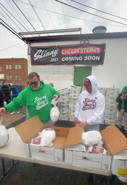 Two men unloading large white containers from a truck under a 'Slimmy Jay's' sign.